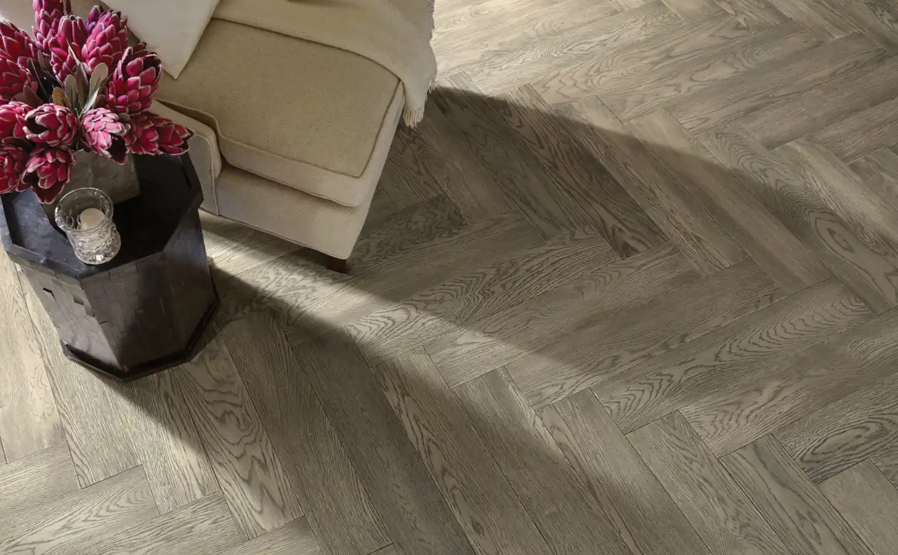 chevron pattern hardwood flooring in sitting area with cream upholstery armchair